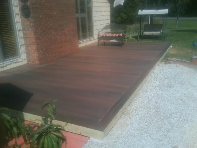 Freshly stained wood deck built against a brick home in Lincoln
